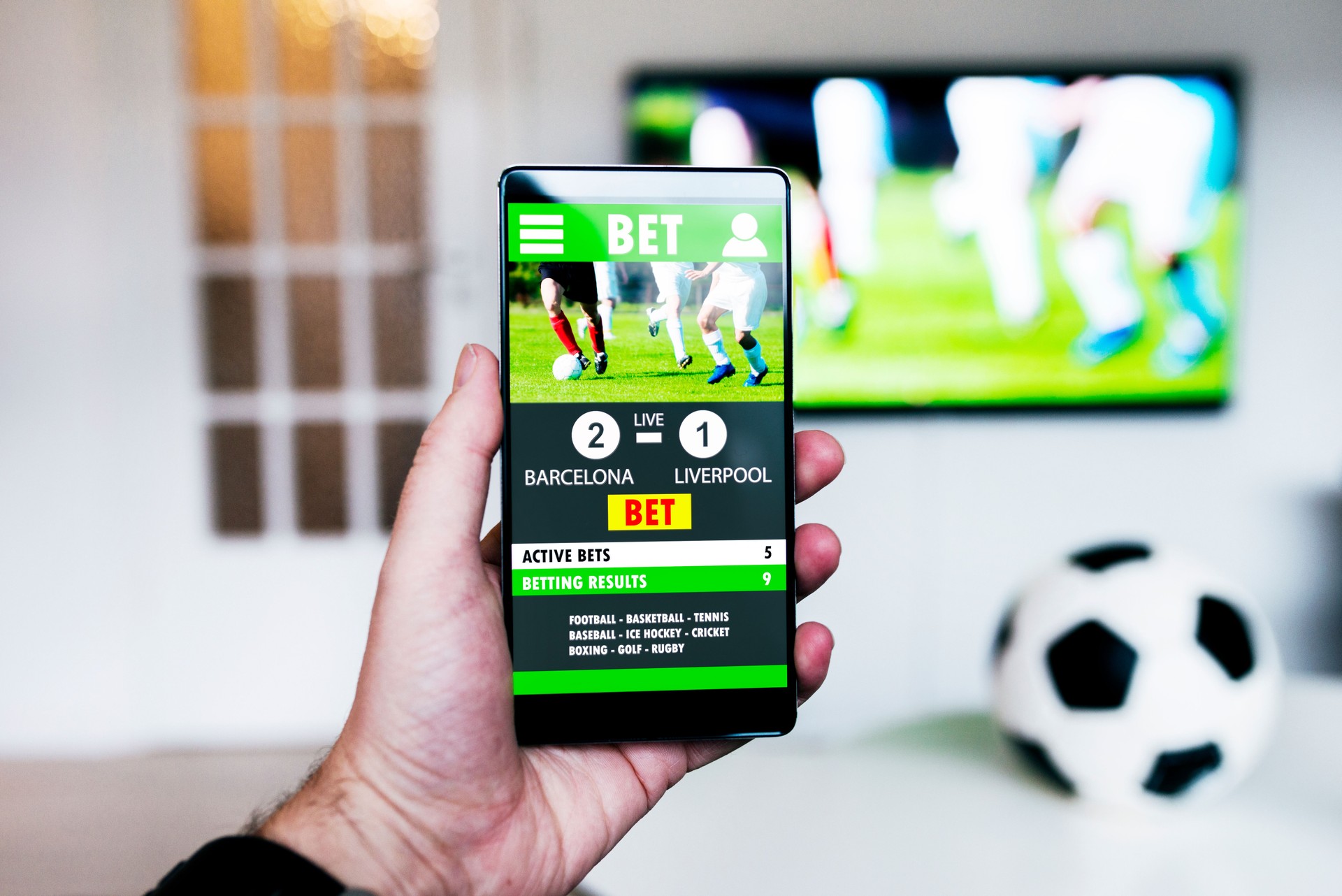 Watching football match on television and betting on the game with smart phone